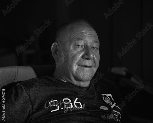 black and white portrait of an old man in low light