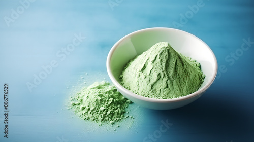 green matcha tea powder on blue background, empty copy space, background healthy food ,show product © YOUCEF