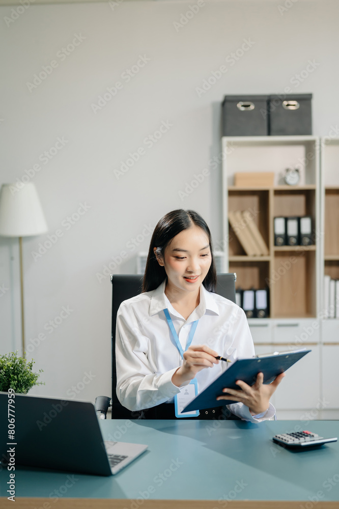 Confident business expert attractive smiling young woman typing laptop and holding digital tablet Confident business expert attractive smiling young woman typing laptop and holding digital tablet