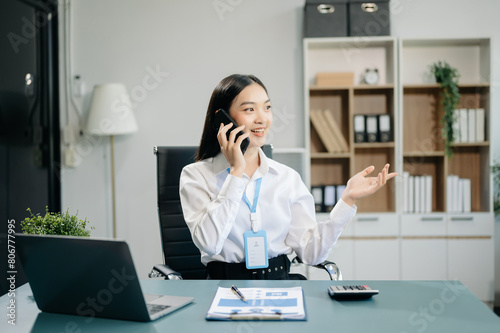 Confident business expert attractive smiling young woman typing laptop and holding digital tablet