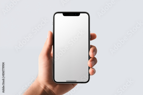 mockup hand holding mobile smartphone with blank, white empty screen on grey background