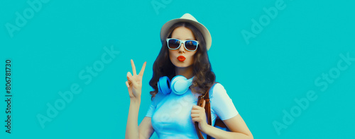 Happy modern happy young woman listening to music with headphones on blue background © rohappy