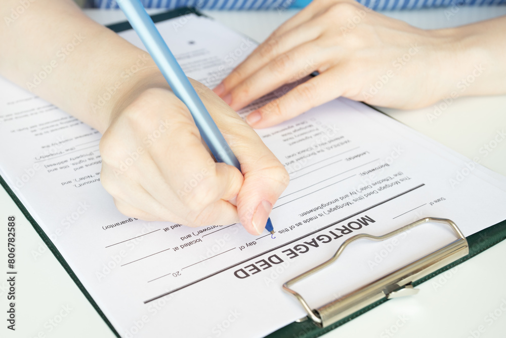 Mortgage deed, hand fills out a document, real estate, property purchase, agreement, signing contract Mortgage deed, hand fills out a document, real estate, property purchase, agreement, signing contract