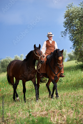 Beautiful Italian woman, riding her Maremmano horse and handling her yearling