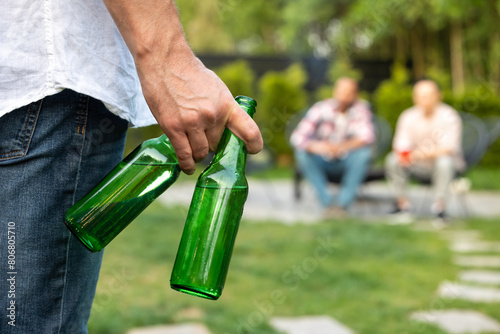 Canvas Print Man with beer bottles joying to friend during backyard party