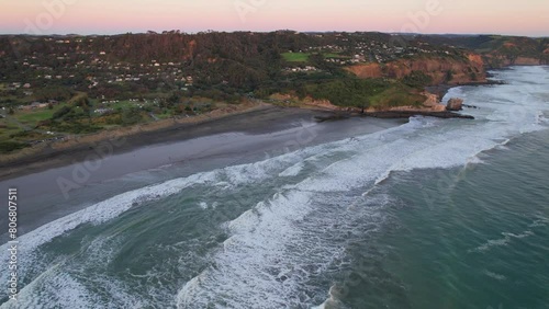 Waves Splashing At Muriwai Beach On Sunset In Auckland's West Coast In New Zealand. aerial shot photo