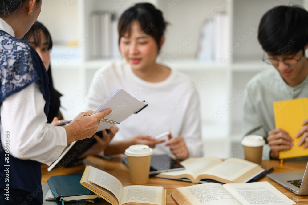 Cropped shot of middle age professor explaining lesson to students during a class Cropped shot of middle age professor explaining lesson to students during a class