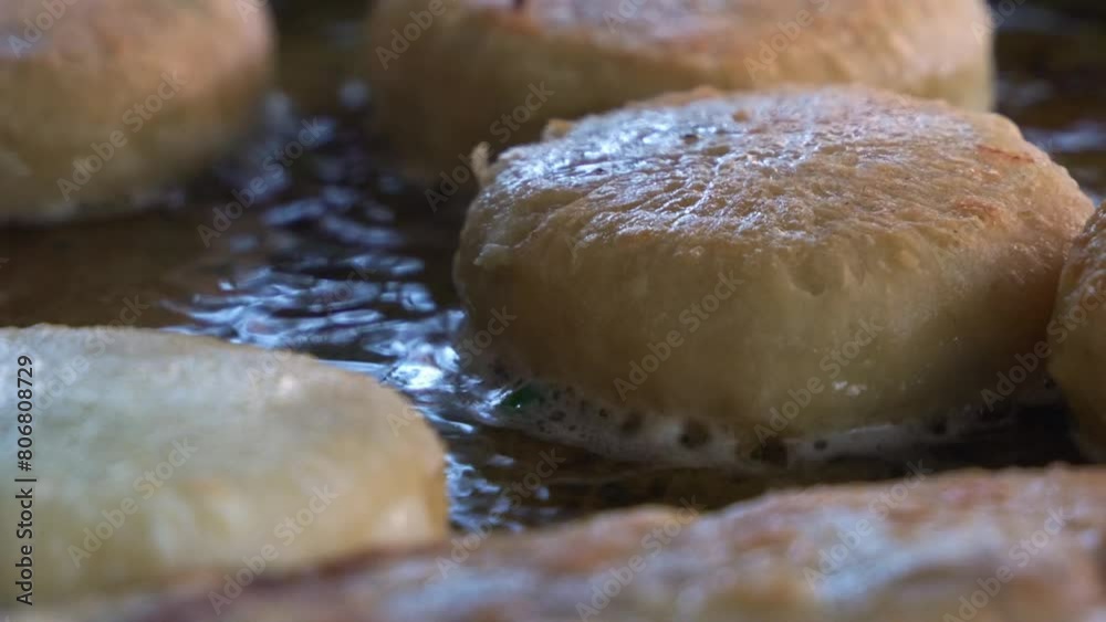 Extreme close up shot of freshly made Chinese meat pie cooking and sizzling on hot oil pan, popular Asian food cooking in process. Extreme close up shot of freshly made Chinese meat pie cooking and sizzling on hot oil pan, popular Asian food cooking in process.