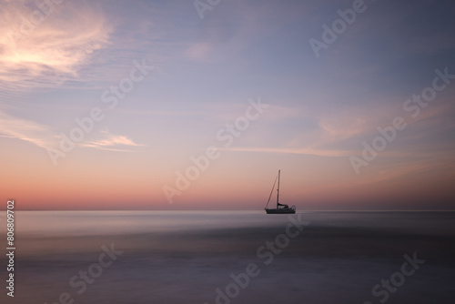 Long exposure shot of a boat at sea in Almunecar, Spain during the morning © Wirestock