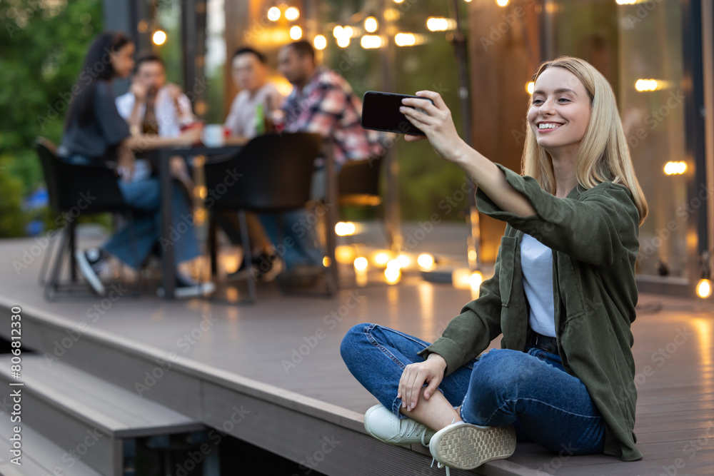 Fototapeta premium Woman making selfie with group of friends spending time making picnic