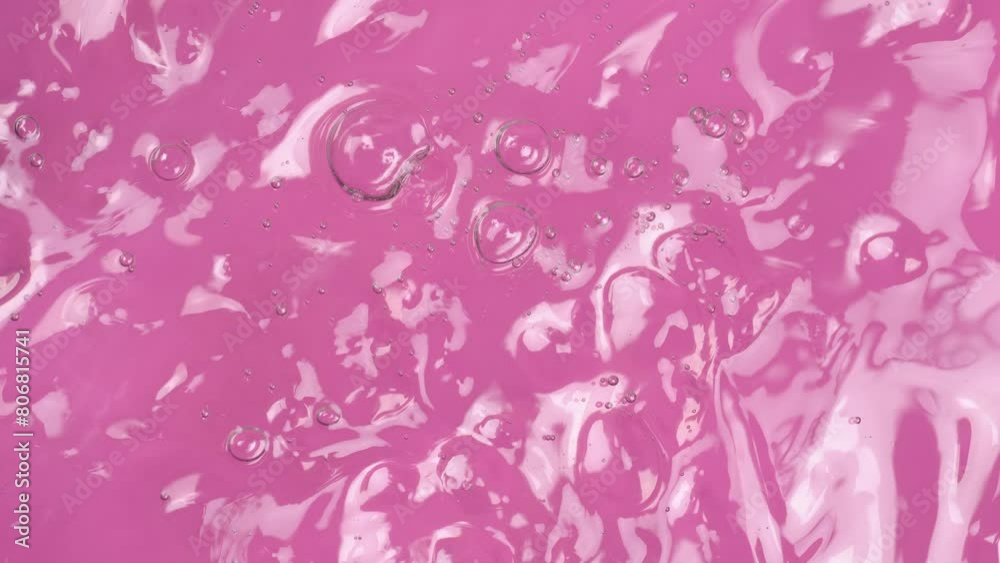 Motion of molecule bubbles in a cosmetic serum, macro. Transparent cosmetic aloe gel with molecule bubbles on pink background. Macro shot of natural organic cosmetics, health care , medicine. Motion of molecule bubbles in a cosmetic serum, macro. Transparent cosmetic aloe gel with molecule bubbles on pink background. Macro shot of natural organic cosmetics, health care , medicine.