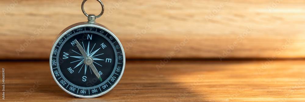 Banner of compass on wooden background with copy space using as direction