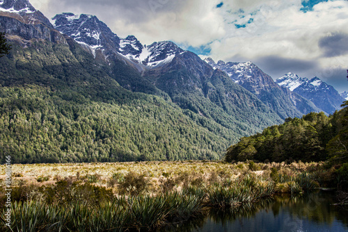 By the shore of Mirror Lakes on Milford Sound Highway Fiordland New Zealand looking up at the snow capped mountains