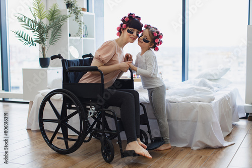 Canvas Print Young woman and cute daughter doing hair perm and applying patches