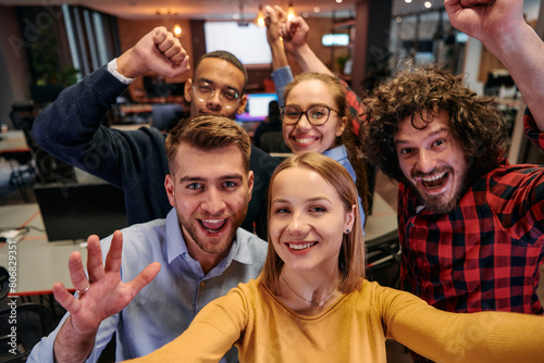 A diverse group of business professionals take a break from their tasks in a modern startup office to capture a creative selfie  showcasing teamwork and a vibrant workplace culture