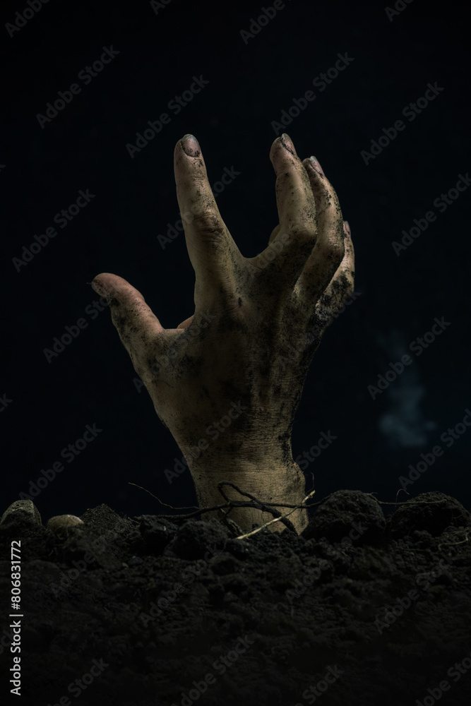 Zombie hand rising from the ground on black background. Halloween concept. Zombie hand rising from the ground on black background. Halloween concept.
