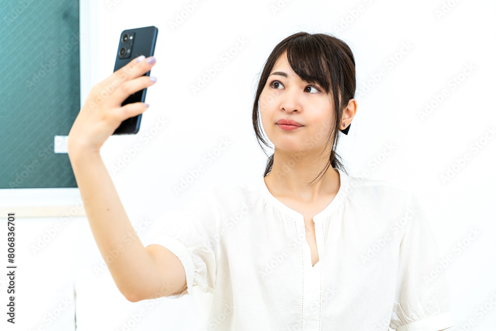 自宅でスマホを触る女性 自宅でスマホを触る女性