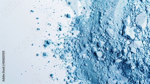 Crushed blue eyeshadow texture, blue powder scattered on a white background