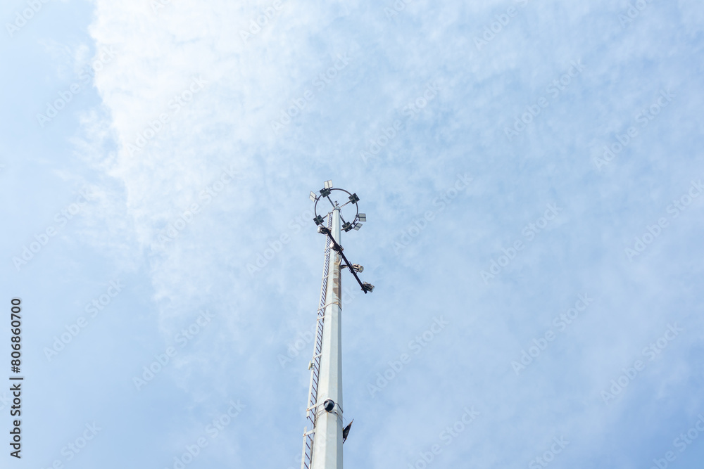 Obraz premium Spotlight pole with clouds and blue sky in background