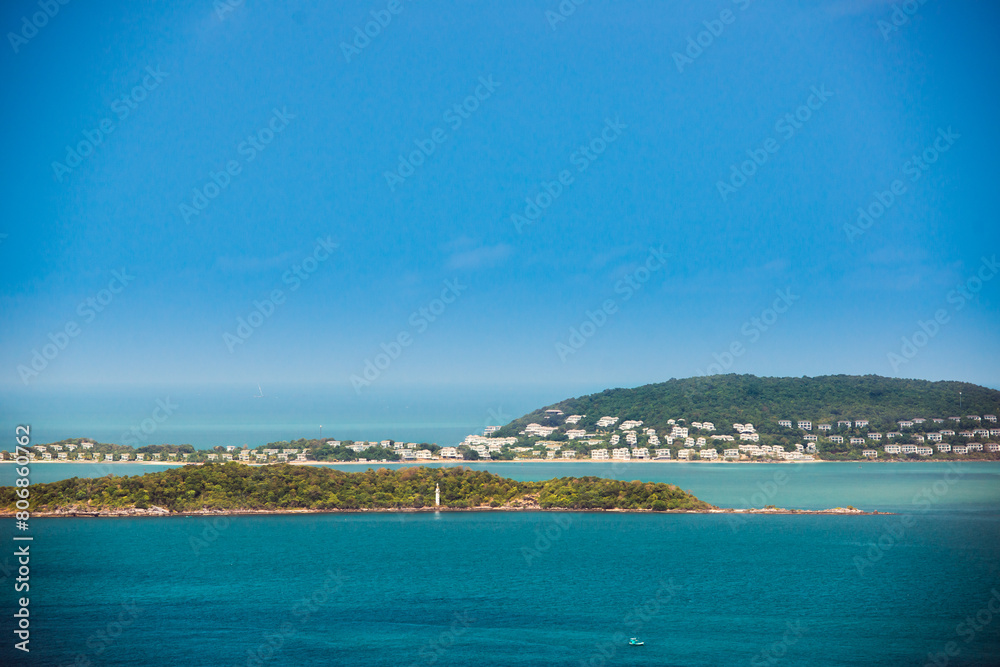 View from the sea of a maritime settlement in Asia. Lighthouse, village, islands, and fishing boat on a beautiful sunny day somewhere in the Gulf of Siam.