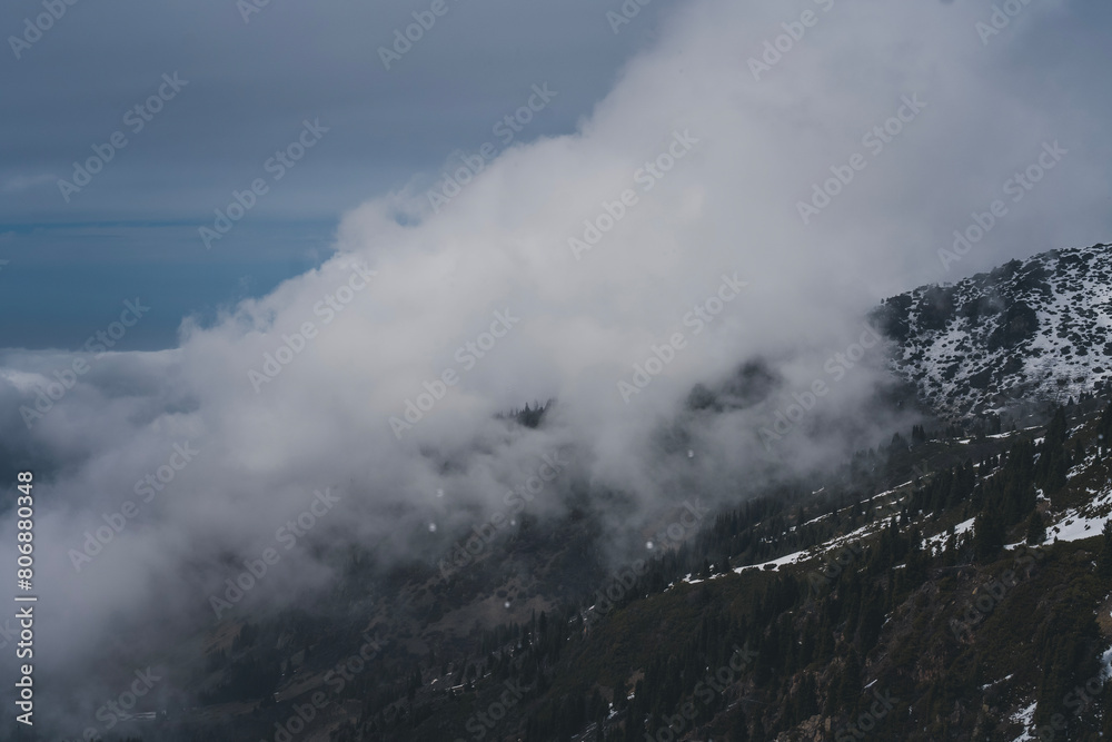 Clouds over snowy mountain peaks, beautiful landscape
