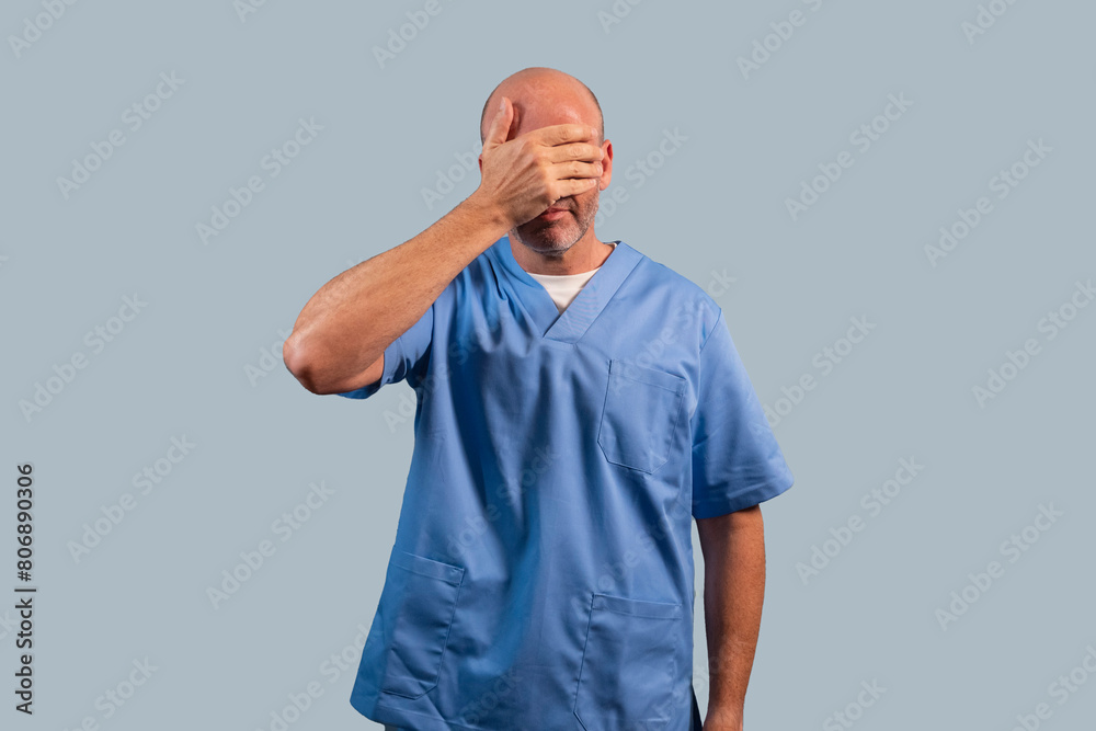 Portrait of a female physiotherapist wearing light blue dress and hands covering her face. Portrait of a female physiotherapist wearing light blue dress and hands covering her face.