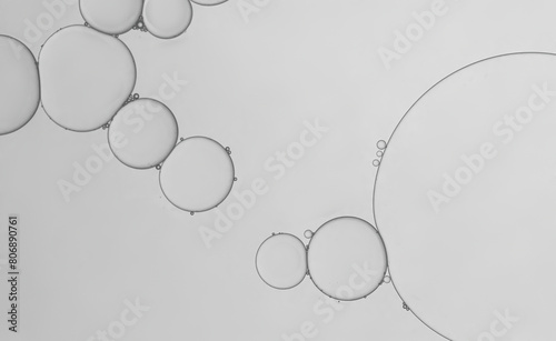 Water and serum oil droplets to creating circle and bubbles shape on grey greadient background.	