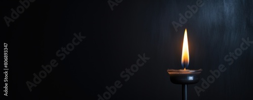 Black background with white thin wax candle with a small lit flame for funeral grief death dead sad emotion with copy space texture for display 