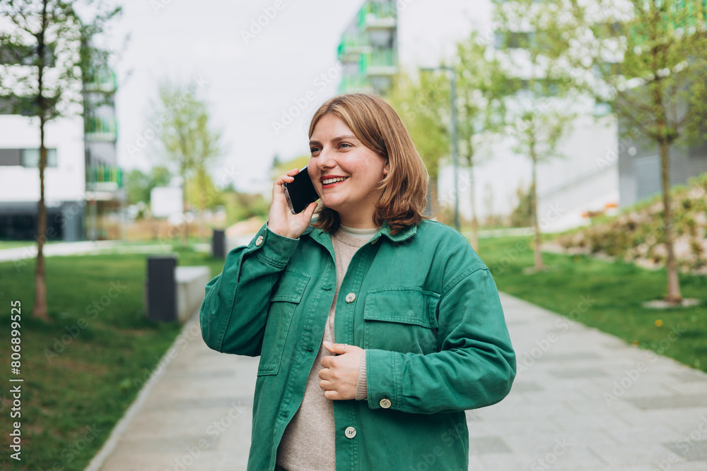 Happy 30s woman talking phone and look happy outdoors Urban lifestyle concept. Summer time. Beautiful woman on the city street. Happy 30s woman talking phone and look happy outdoors Urban lifestyle concept. Summer time. Beautiful woman on the city street.