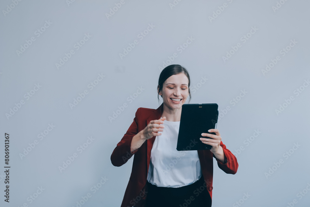 Photo of young attractive happy positive woman hold pc tablet hand touch chin isolated over grey color background Photo of young attractive happy positive woman hold pc tablet hand touch chin isolated over grey color background