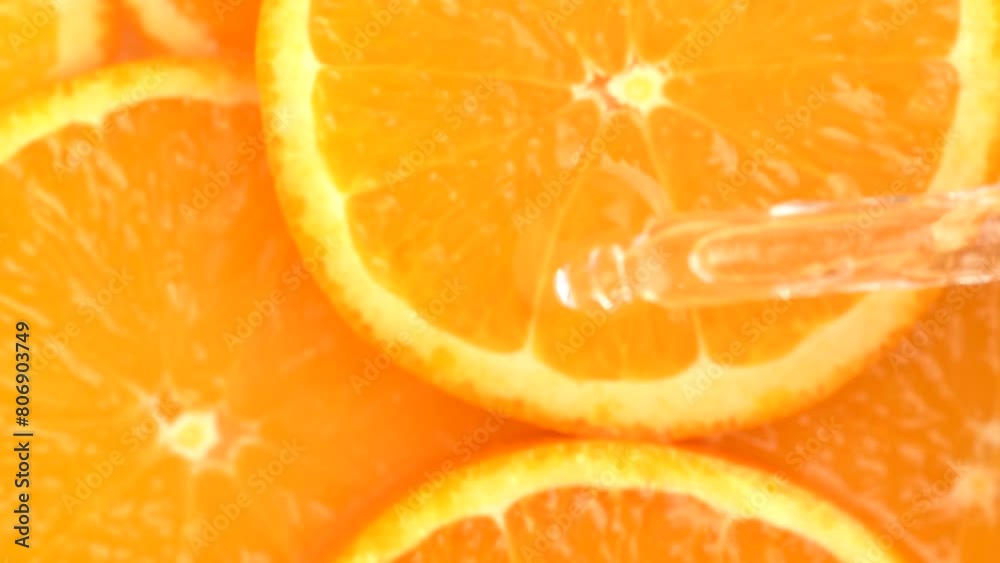 Oily orange essence drop from pipette into orange slices. Essential oil dripping from pipette dropper, macro Oily orange essence drop from pipette into orange slices. Essential oil dripping from pipette dropper, macro