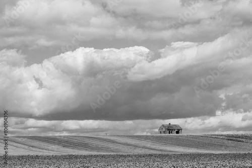 maison abandonnée au milieu des champs à la campagne sous un ciel de tempête d'orage
