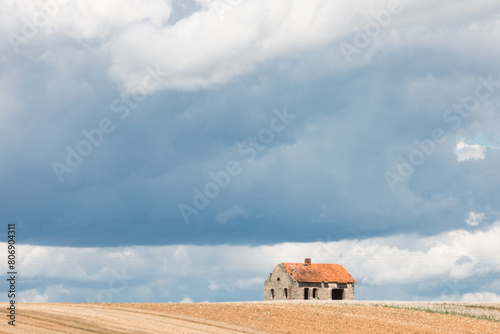 maison abandonnée au milieu des champs à la campagne sous un ciel de tempête d'orage