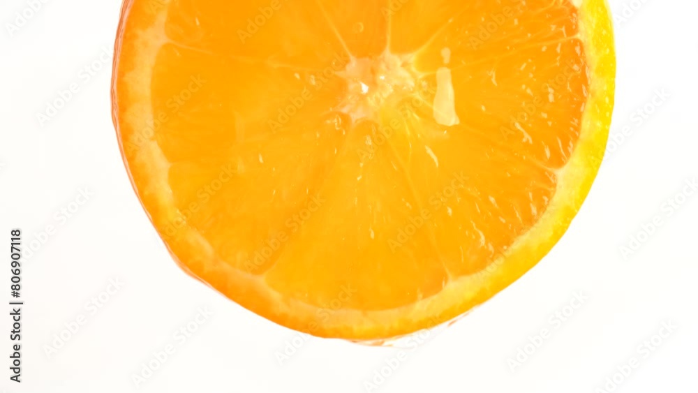 Natural essential oil or serum flows down from orange on white background. Orange slice and water splashing, drops of juice falling from juicy fruit. Natural essential oil or serum flows down from orange on white background. Orange slice and water splashing, drops of juice falling from juicy fruit.