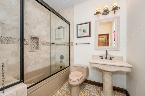 a bathroom with white walls and beige tile flooring and tub and vanity