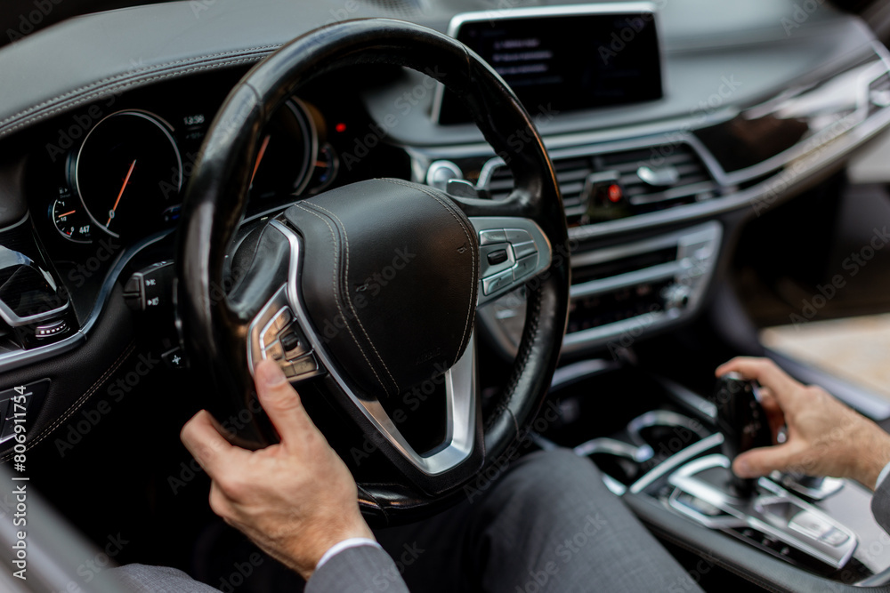 Smiling man enjoying a sunny drive in a modern car interior Smiling man enjoying a sunny drive in a modern car interior