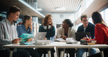 Diverse Group of Students Engaged in a Study Session at a Modern Library. Young Adults Collaborating Over Books and Laptops, Sharing Ideas and Learning Together in a Collegiate Environment.