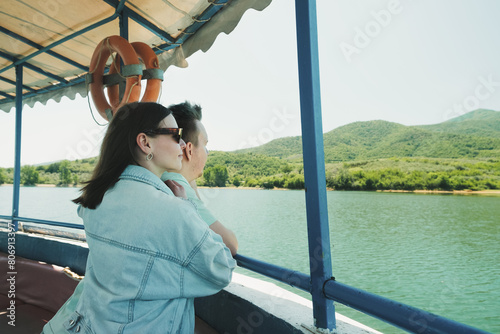 Happy young couple sailing on a boat on the lake and enjoying the stunning view.