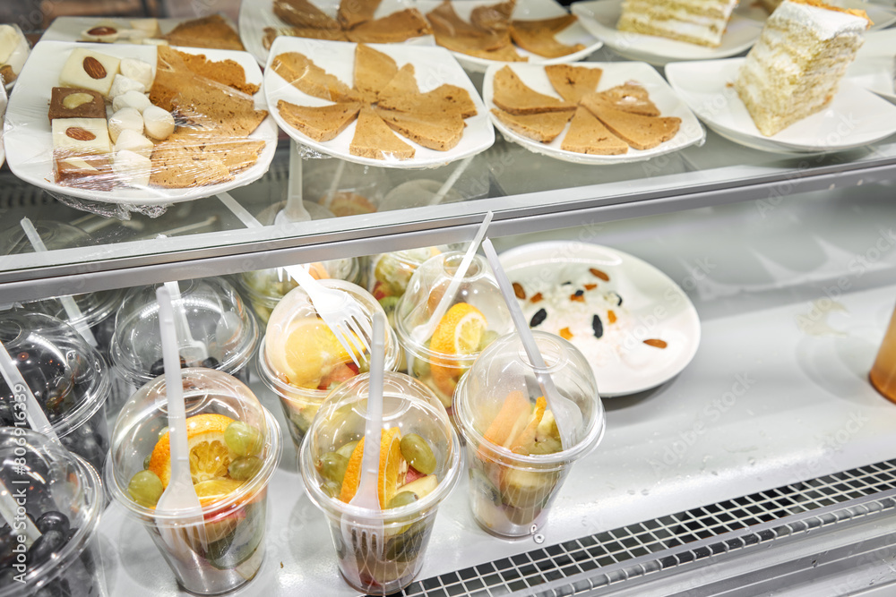 Display case showcasing a variety of desserts and fruit cups Display case showcasing a variety of desserts and fruit cups