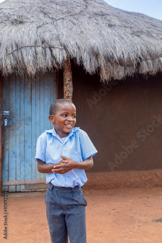 african village, happy kid in school uniform preparing for school in the yard, back to school