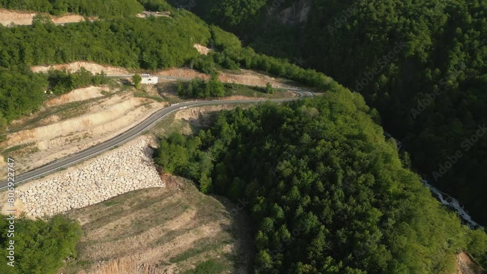 Aerial view drone flying above serpentine road,car on the mountains in sunny day Aerial view drone flying above serpentine road,car on the mountains in sunny day