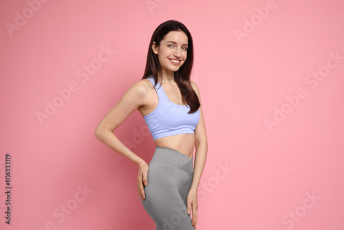 Happy young woman with slim body on pink background © New Africa