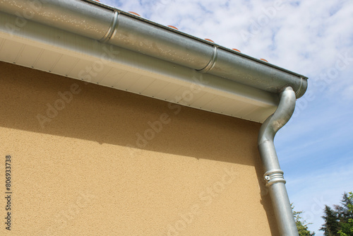 Gouttière zinc gris sur la façade de la maison, descentes et lambris de sous-face en PVC blanc  photo