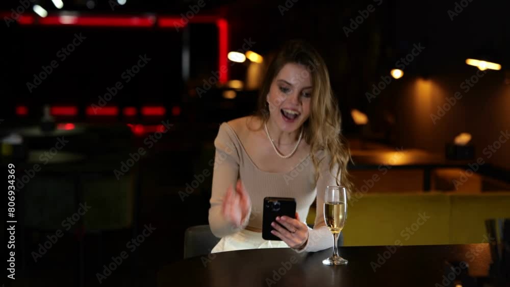 Young pretty woman sitting in the restaurant and reading message. Surprised lady looking at mobile phone screen. Lifestyle concept. Real time. Young pretty woman sitting in the restaurant and reading message. Surprised lady looking at mobile phone screen. Lifestyle concept. Real time.