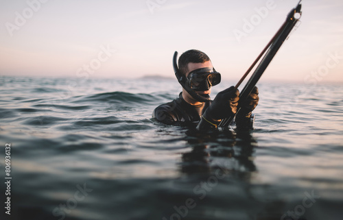 Spearfisherman prepare speargun for fish hunting photo