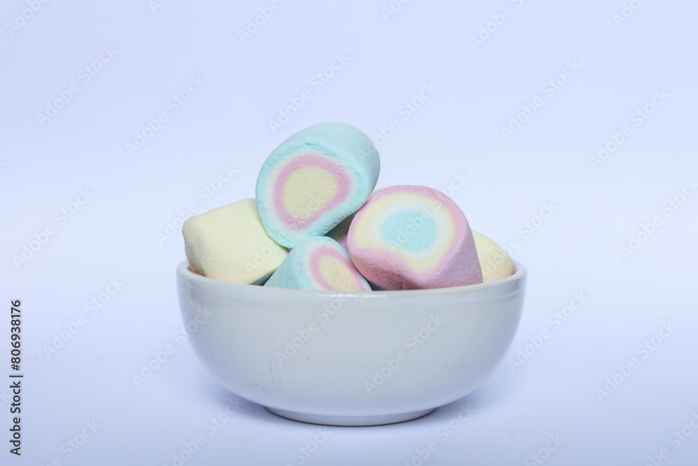 Fototapeta premium Colorful marshmallows in a bowl on a white background.