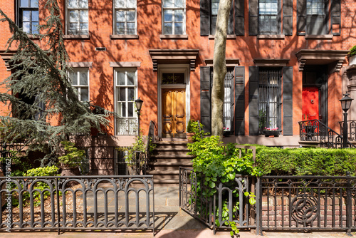 Townhouses with red brick facades in Chelsea Historic District in summer. Manhattan, New York City