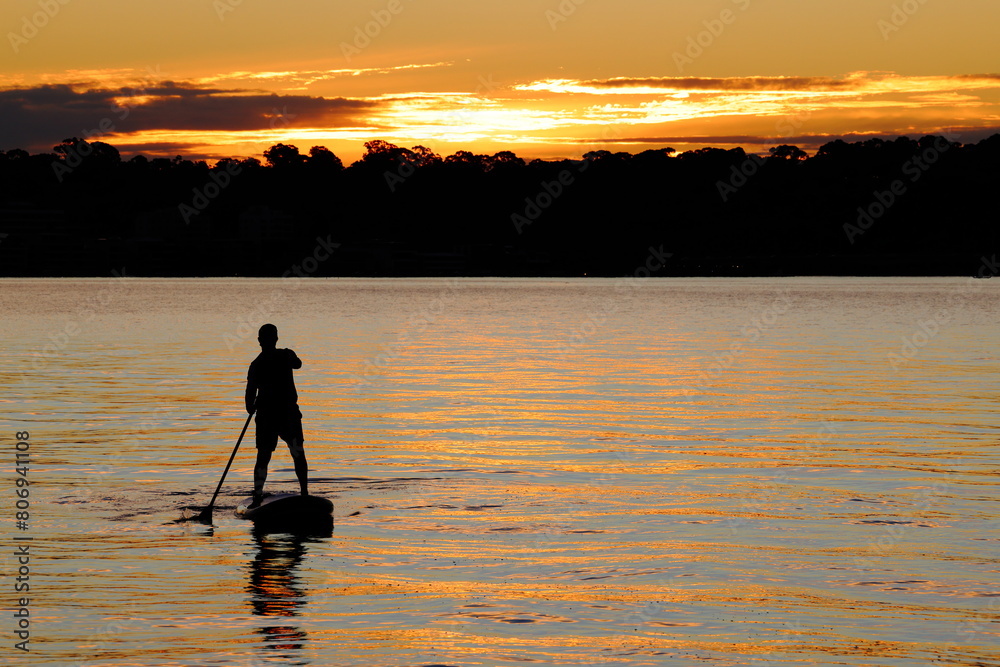 Silhouette of young man, stand up (SUP) paddle board, sunset, Swan River, Perth, Western Australia, copy space
