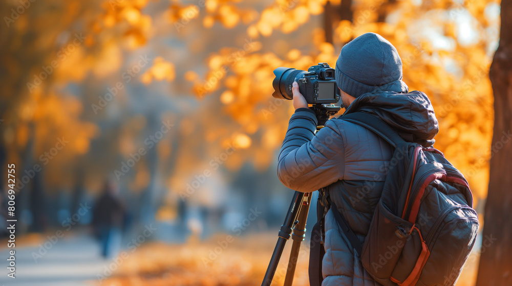 Photographer Capturing Autumn Scenery in Park with Golden Leaves