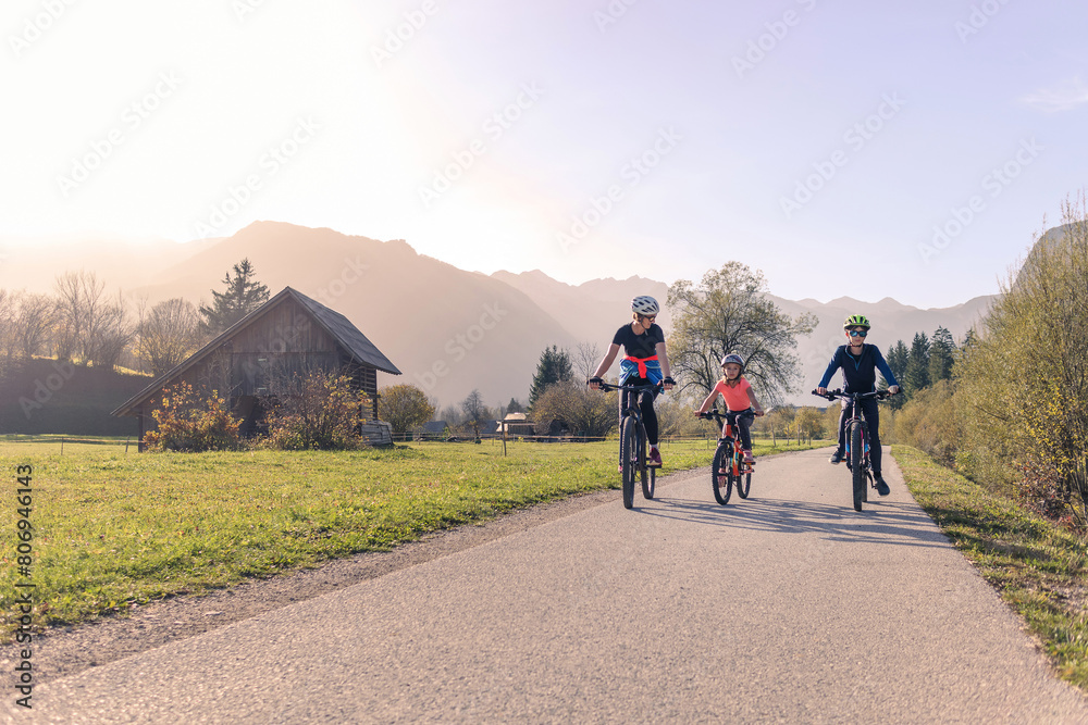 Obraz premium Mother with two children boy and girl on a cycling trip in nature